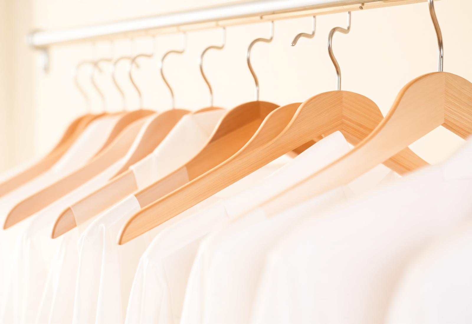 Freshly cleaned shirts on wooden hangers at Westborn Cleaners